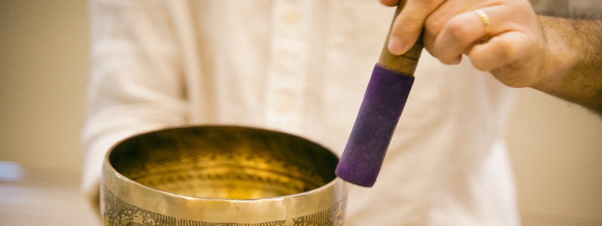 Hands playing a Tibetan singing bowl